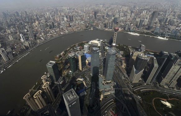 The skyline of Shanghai spreads out below the shadow of the 632-meter (2,073 feet) tall Shanghai Center Tower in Shanghai, China, Sunday, March 22, 2015. The 550-meter (1,804 feet) high observation de ...