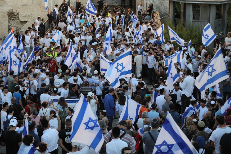 epa09273800 Israelis march with the national flags near the Damascus gate during the Flags March in the old city of Jerusalem, 15 June 2021. The Flag March went on despite threats by the Palestinian m ...