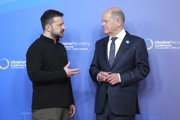 Ukrainian President Volodymyr Zelenskyy, left, and German Chancellor Olaf Scholz talk at the start of the Ukraine recovery conference in Berlin, Germany, Tuesday, June 11, 2024. Germany is hosting a c ...