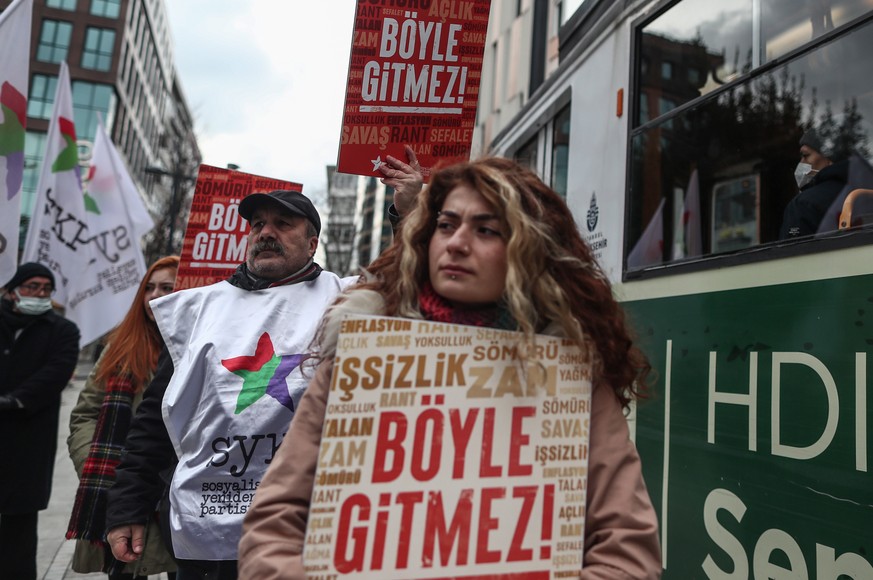 epa09701919 A protester holds a placard reading &#039;It doesn&#039;t go on like this&#039; during the protest against price hikes after the Turkish Lira crises in Istanbul, Turkey, 22 January 2022. T ...