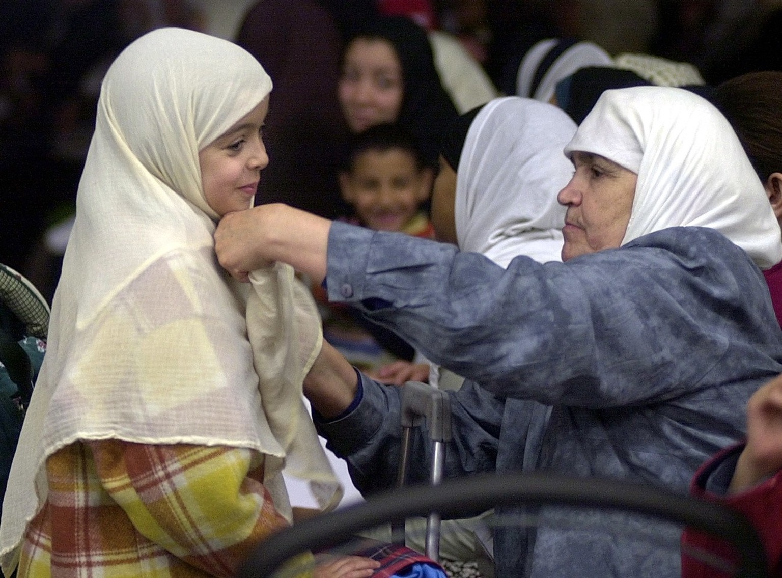 A muslim woman, left, adjusts the veil of a young girl during the 19th conference of the Union of islamic organisations of France (UOIF) at Le Bourget airport exhibition hall, north of Paris, Sunday M ...