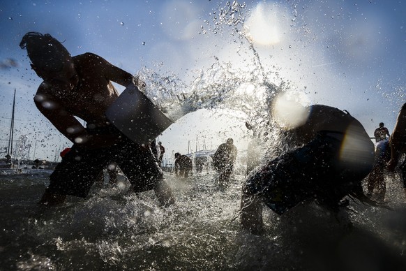 People throw water at each other during a 10-minute long water battle flash mob in Lausanne, Switzerland, Friday, July 3, 2015. The temperatures have been reaching over 35 degrees Celsius for several  ...