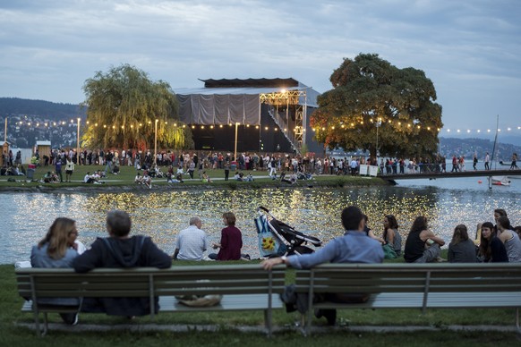 Besucher des Theaterspektakels verweilen auf der Wiese am Freitag, 19. August 2016 auf der Landiwiese in Zuerich. Das Zuercher Theater Spektakel dauert vom 18. August bis zum 4. September 2016. (KEYST ...