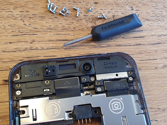 Ein Mini-Schraubenzieher liegt dem Fairphone 3 bei. Oben rechts ist das wechselbare Kameramodul zu sehen.