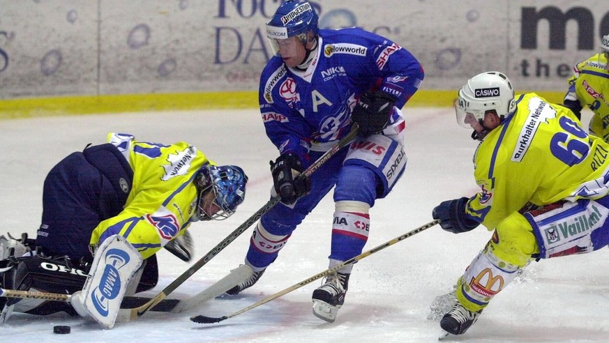 Klotens Andre Rufener, Mitte, bedraengt den Davoser Torhueter Lars Weibel, links, als Zuschauer Sandro Rizzi, rechts beim Eishockeyspiel der NLA EHC Kloten - HC Davos in Kloten am Samstag 15. Septembe ...