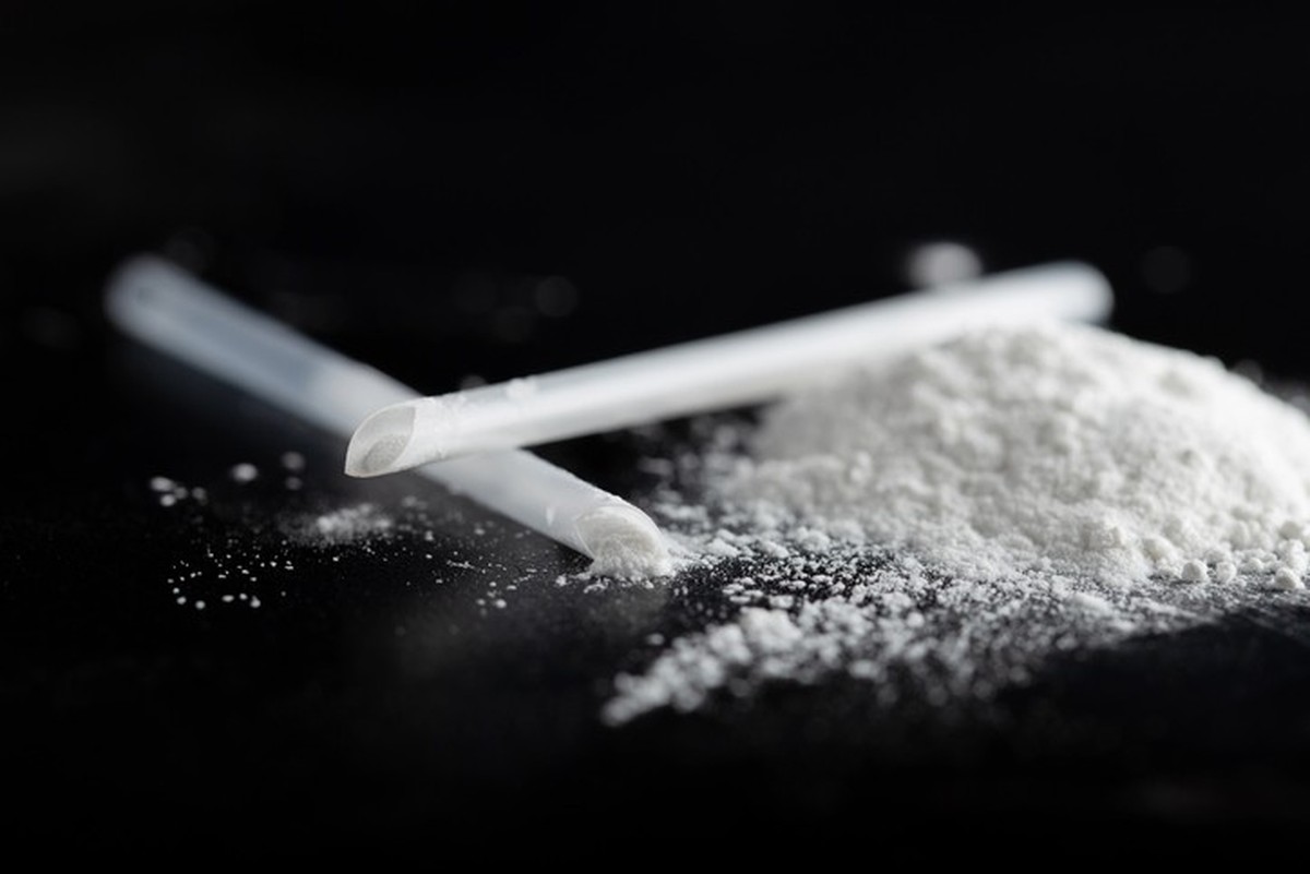 ketamine drugs and plastic straw on black wood background.Drug epidemic concept