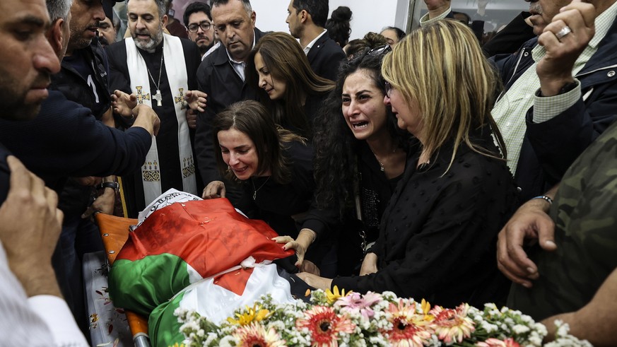 epa09940328 Colleagues react as the body of veteran Al-Jazeera journalist Shireen Abu Akleh is brought to the offices of the news channel in the West Bank city of Ramallah, 11 May 2022. Al-Jazeera sai ...