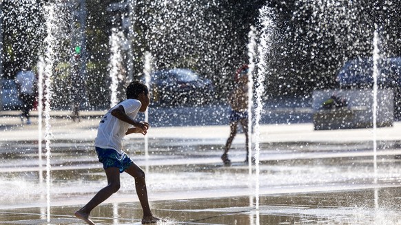 KEYPIX - Un enfant joue dans les jets d&#039;eau de la fontaine de la place des Nations lors de l&#039;alerte canicule, ce vendredi 8 aout 2025 a Geneve. Pour la deuxieme fois cet ete a Geneve, le Ser ...