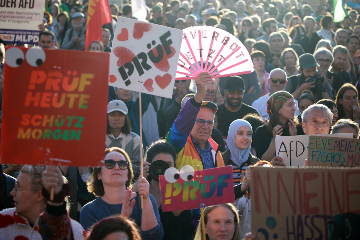 epa13220437 Participants hold placards during a rally at the Brandenburg Gate in Berlin, Germany, 07 September 2026. The protest was scheduled a day after the far-right Alternative for Germany party ( ...