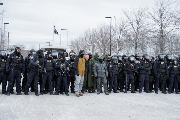 epa12652561 US Border Patrol Chief Patrol Agent Gregory Bovino (C) stands among Minneapolis Police Department and federal agents during an anti-ICE protest outside the Whipple Federal Building, a base ...
