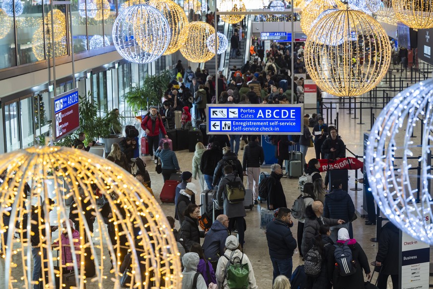 Des passagers arrivent avec leurs bagages devant les guichets d&#039;embarquement du terminal principal de l&#039;aeroport international de Geneve (AIG), ce samedi 23 decembre 2023 a Geneve. L&#039;ae ...