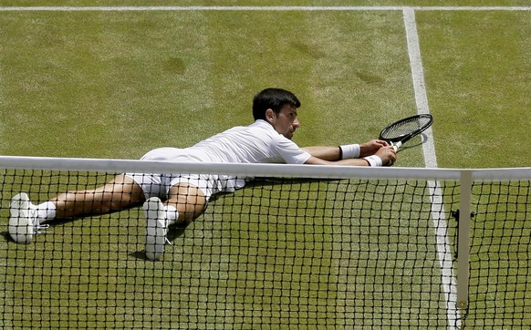 epa07712312 Novak Djokovic of Serbia in action against Roberto Bautista Agut of Spain during their semi final match for the Wimbledon Championships at the All England Lawn Tennis Club, in London, Brit ...