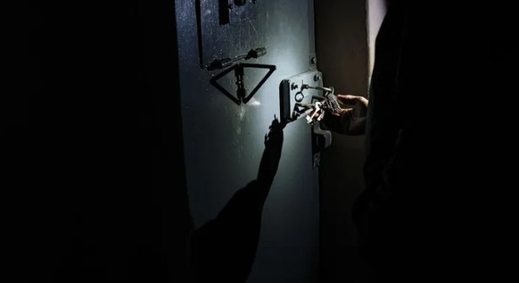 A police officer unlocks Sayapin's former cell.