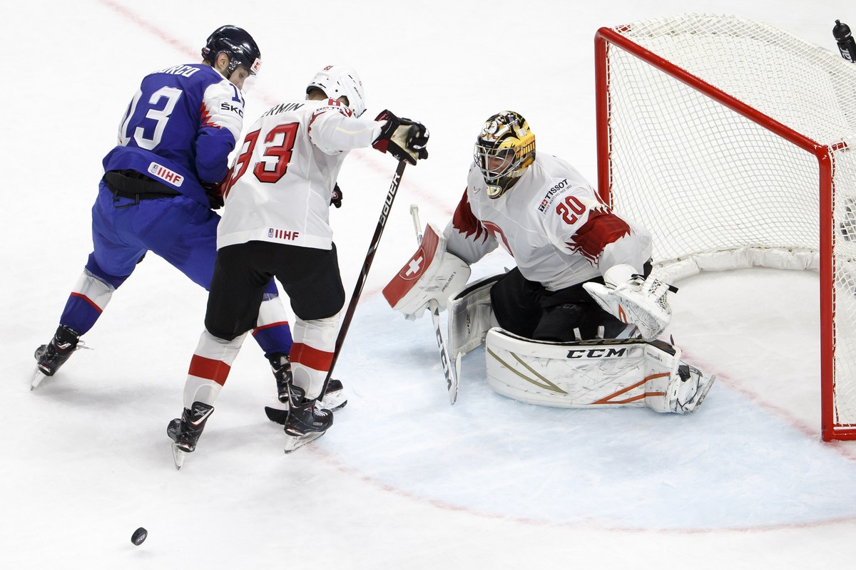 Slovakia's forward Tomas Jurco, left, vies for the puck with Switzerland's forward Joel Vermin, center, past Switzerland's goaltender Reto Berra, right, during the IIHF 2018 World Champ ...