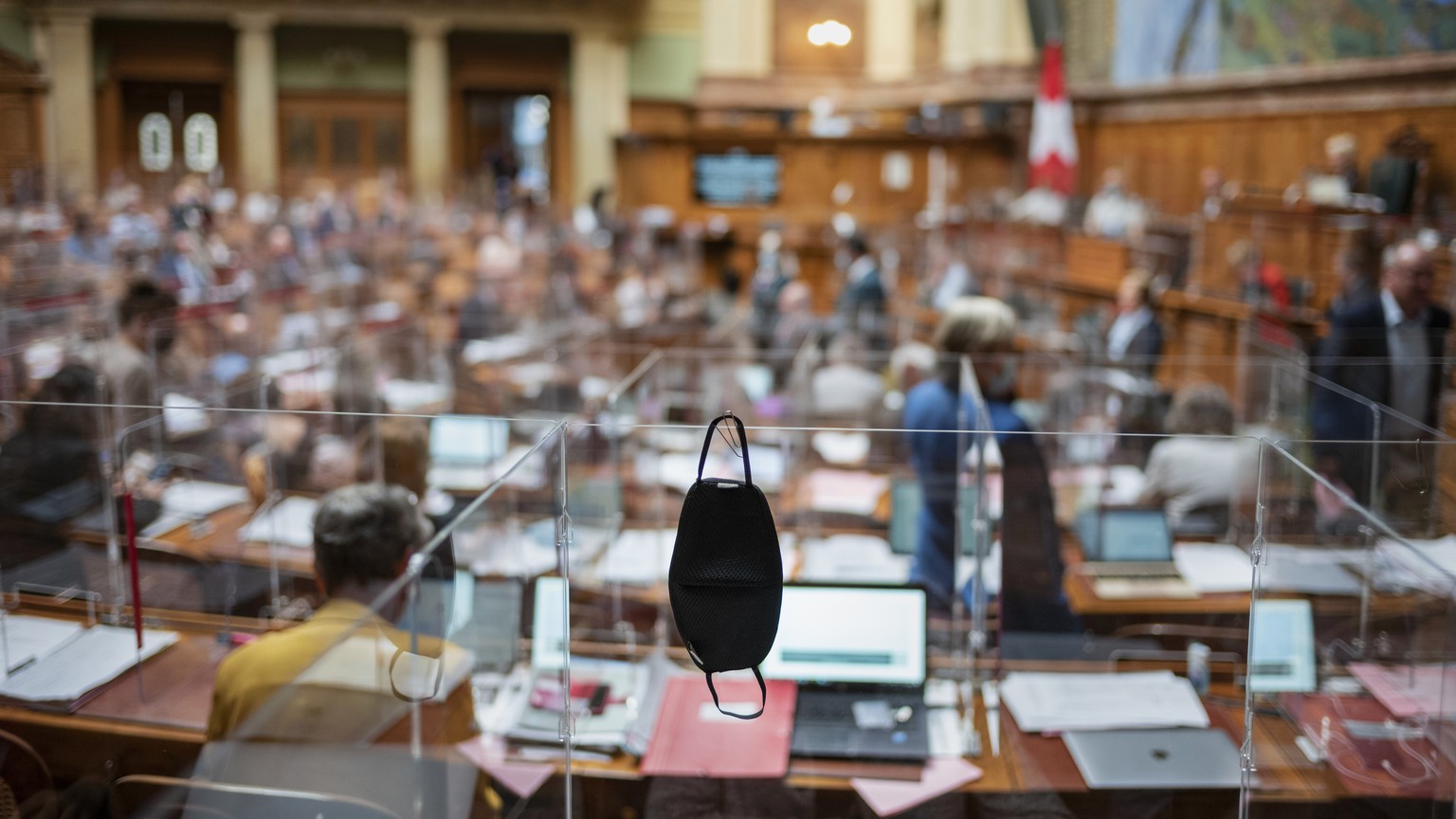 Eine Schutzmaske haengt an einer Plexiglasscheibe, an der Herbstsession der Eidgenoessischen Raete, am Mittwoch, 9. September 2020 im Nationalrat in Bern. Aufgrund der Krise um die Pandemie des Corona ...