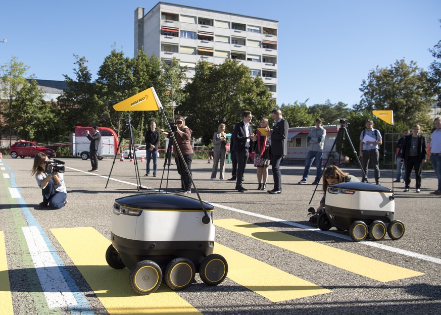 Selbstfahrende Lieferroboter passieren einen Fussgaengerstreifen von PostLogistcs fuer den Zustelldienst der Post im Praxistest vor den Medien am Dienstag, 23. August 2016, in Bern. (KEYSTONE/Lukas Le ...