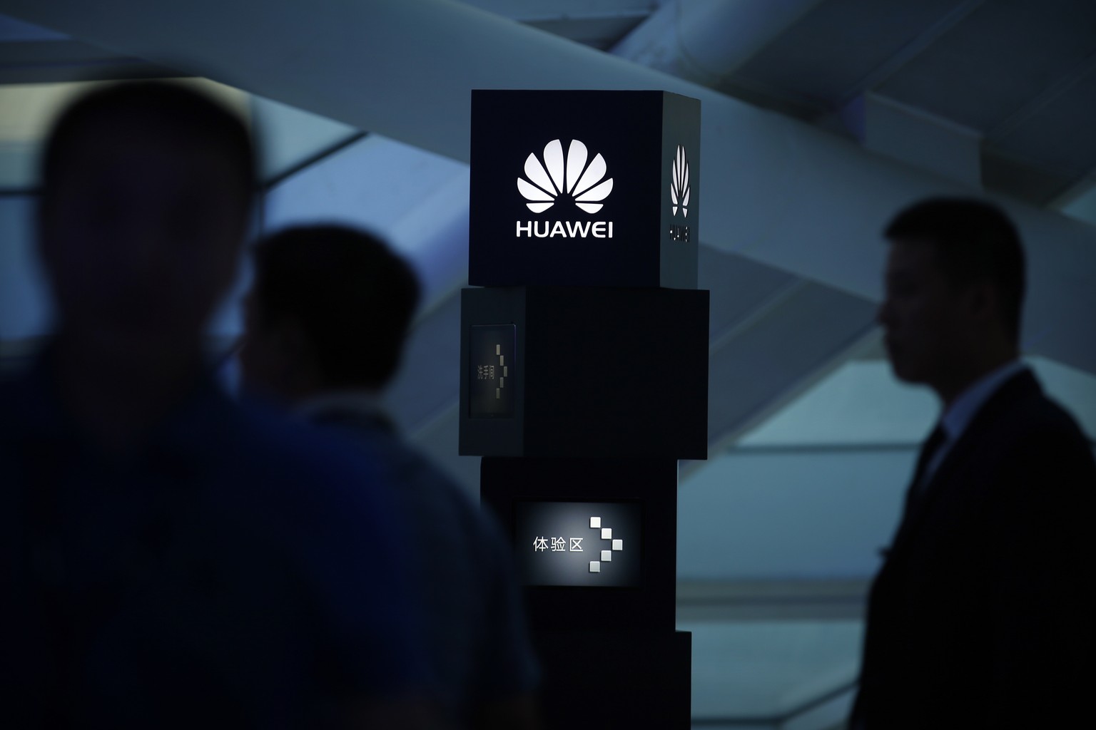 FILE - In this June 26, 2016 file photo, visitors attend a launch event for the Huawei MateBook in Beijing. France's President Emmanuel Macron is cautioning against freezing out Chinese tech giant Hua ...