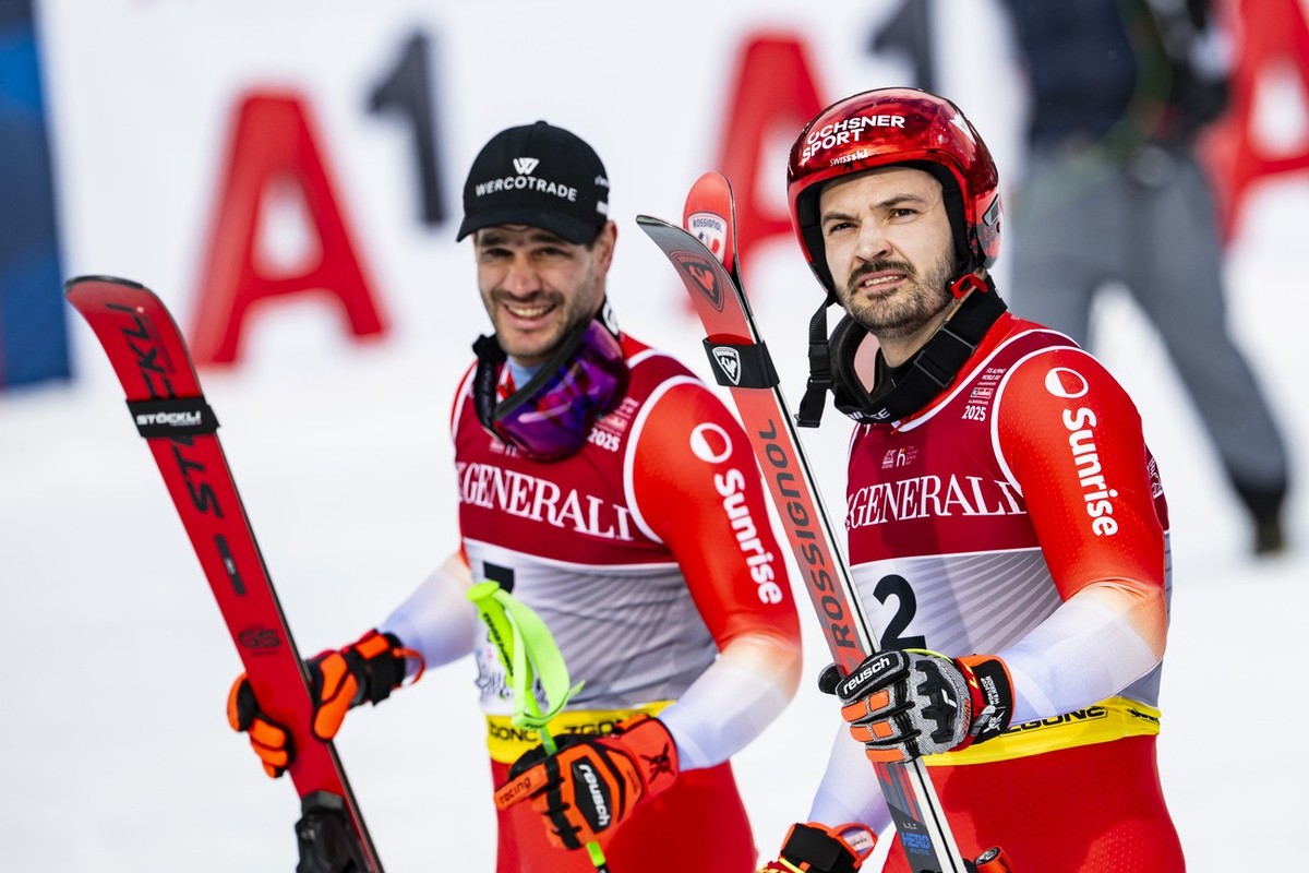 Silver medalist Thomas Tumler of Switzerland, left, and Bronze medalist Loic Meillard of Switzerland, right, react in the finish area during the second run of the men's Giant Slalom race at the 2 ...
