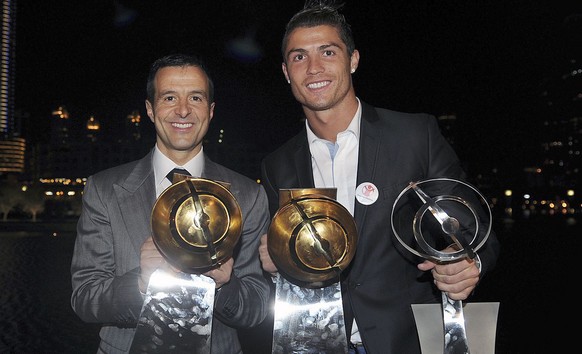 epa03044492 Real Madrid soccer player, Portuguese Cristiano Ronaldo (R), and his manager Jorge Mendes (L), pose with the trophies won during the Globe Soccer Awards ceremony held at Dubai, UAE, 28 Dec ...