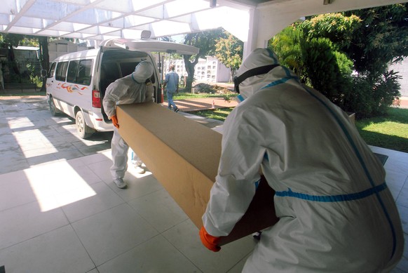 epa08549978 Officials from the Mayor&#039;s Office of Santa Cruz carry a cardboard coffin onto a vehicle, in Santa Cruz, Bolivia, 16 July 2020. The poorest families in the Bolivian city of Santa Cruz, ...