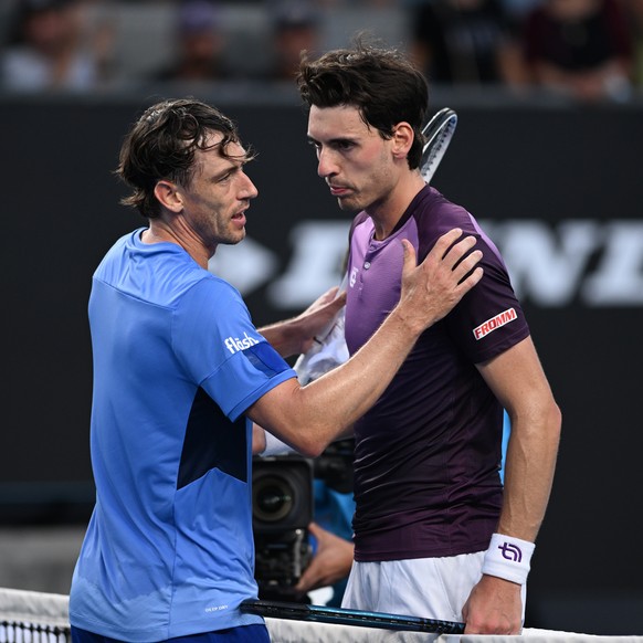 epa10408510 John Millman (L) of Australia celebrates winning against Marc-Andrea Huesler of Switzerland during their Men?s Singles first round match at the 2023 Australian Open tennis tournament at Me ...