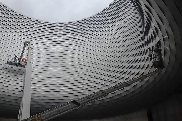 Hier wird das Flechtwerk der Fassade des Messebaus von Herzog und de Meuron mit Hilfe einer Hebebühne gereinigt.