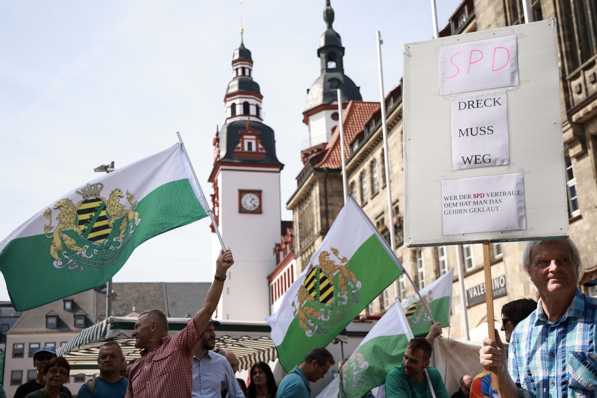 epa11573160 Counter protesters of the far right movement Free Saxons (Freie Sachsen) wave flags as they demonstrate prior to an election campaign rally of the Saxony's Social Democratic Party (SP ...
