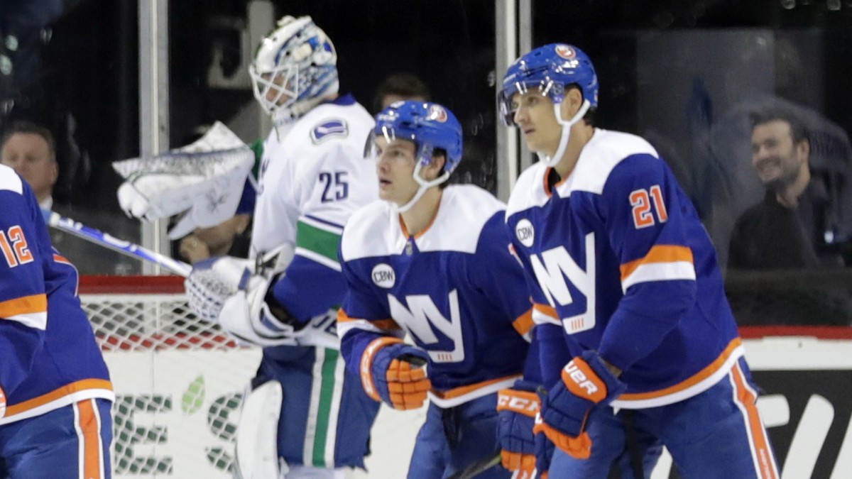 New York Islanders' Josh Bailey (12) skates past Vancouver Canucks goaltender Jacob Markstrom (25) with teammates Mathew Barzal and Luca Sbisa (21) after scoring a goal during the first period of ...