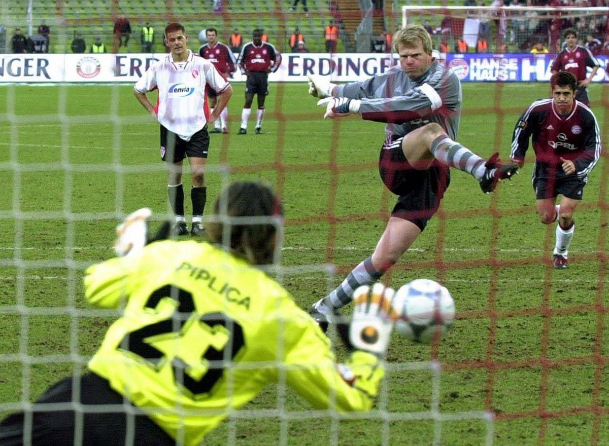 MUN89 - 20020223 - MUNICH, GERMANY : Bayern Munich's goalkeeper Oliver Kahn (C-L) kicks a penalty against Cottbus goalie Tomislav Piplica (front) during their German Bundesliga soccer match in Mu ...