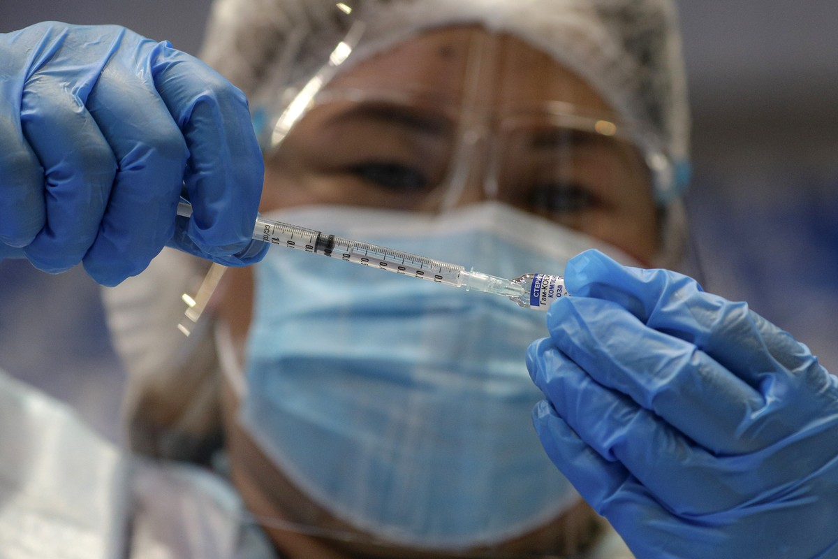 FILE - A health worker prepares to administer Russia's Sputnik V COVID-19 vaccine inside the Makati Coliseum, in Manila, Philippines on May 4, 2021. On Monday, the U.S. will implement a new air t ...