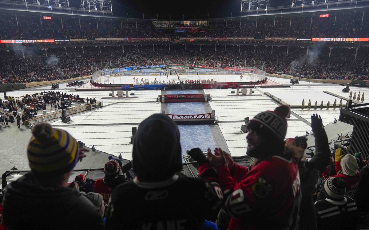 Fans celebrate after a goal by the Chicago Blackhawks against the St. Louis Blues during the third period of the NHL Winter Classic outdoor hockey game at Wrigley Field, Tuesday, Dec. 31, 2024, in Chi ...