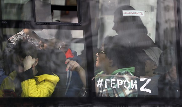 epa10590943 People travel on a city bus with a sign in the window bearing a hashtag in support of the Russian army, reading &#039;#HEROES Z,&#039; in Podolsk, outside Moscow, Russia, 25 April 2023. EP ...