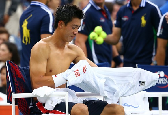 NEW YORK, NY - SEPTEMBER 08: Kei Nishikori of Japan changes his shirt during a change over against Marin Cilic of Croatia during their men&#039;s singles final match on Day fifteen of the 2014 US Open ...