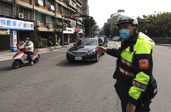 epa09798222 A police officer gives instructions as traffic lights are down, following a nationwide blackout jeopardising transportation and the private sectors across island, in Taipei, Taiwan, 03 Mar ...