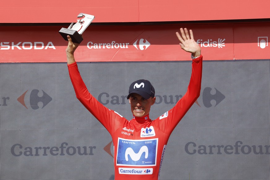 epa13222702 Spanish cyclist Enric Mas of Movistar wears the red overall leader's jersey on the podium following the wears the red overall leader's jersey on the podium following the Stage 16 ...