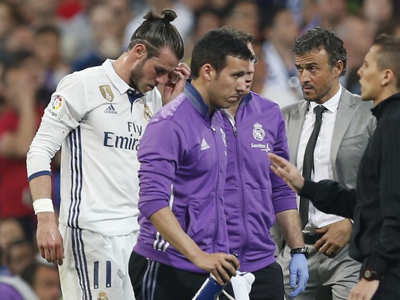 Real Madrid&#039;s Gareth Bale leaves the field of play after being injured, as Barcelona&#039;s head coach Luis Enrique looks on during a Spanish La Liga soccer match between Real Madrid and Barcelon ...