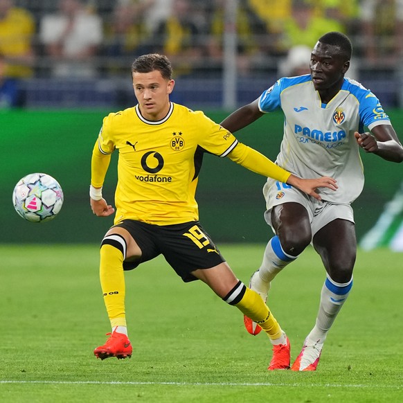 Villarreal's Pape Gueye, right, and Dortmund's Konstantinos Karetsas challenge for the ball during the Champions League opening phase soccer match between Borussia Dortmund and Villarreal in ...