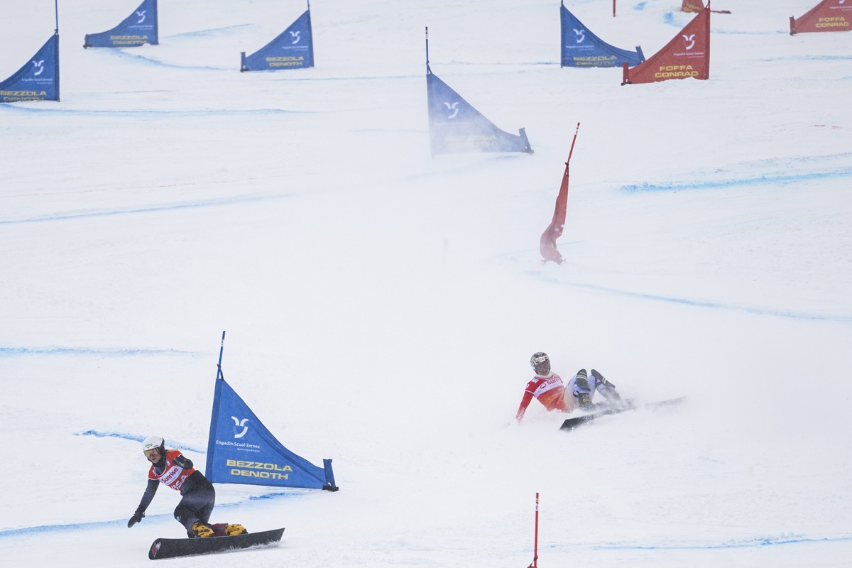 Julie Zogg of Switzerland, right, crashes during finals at the FIS Alpine Snowboard Parallel Giant Slalom race, on Saturday, January 10, 2026, in Scuol, Switzerland. (KEYSTONE/Gian Ehrenzeller)