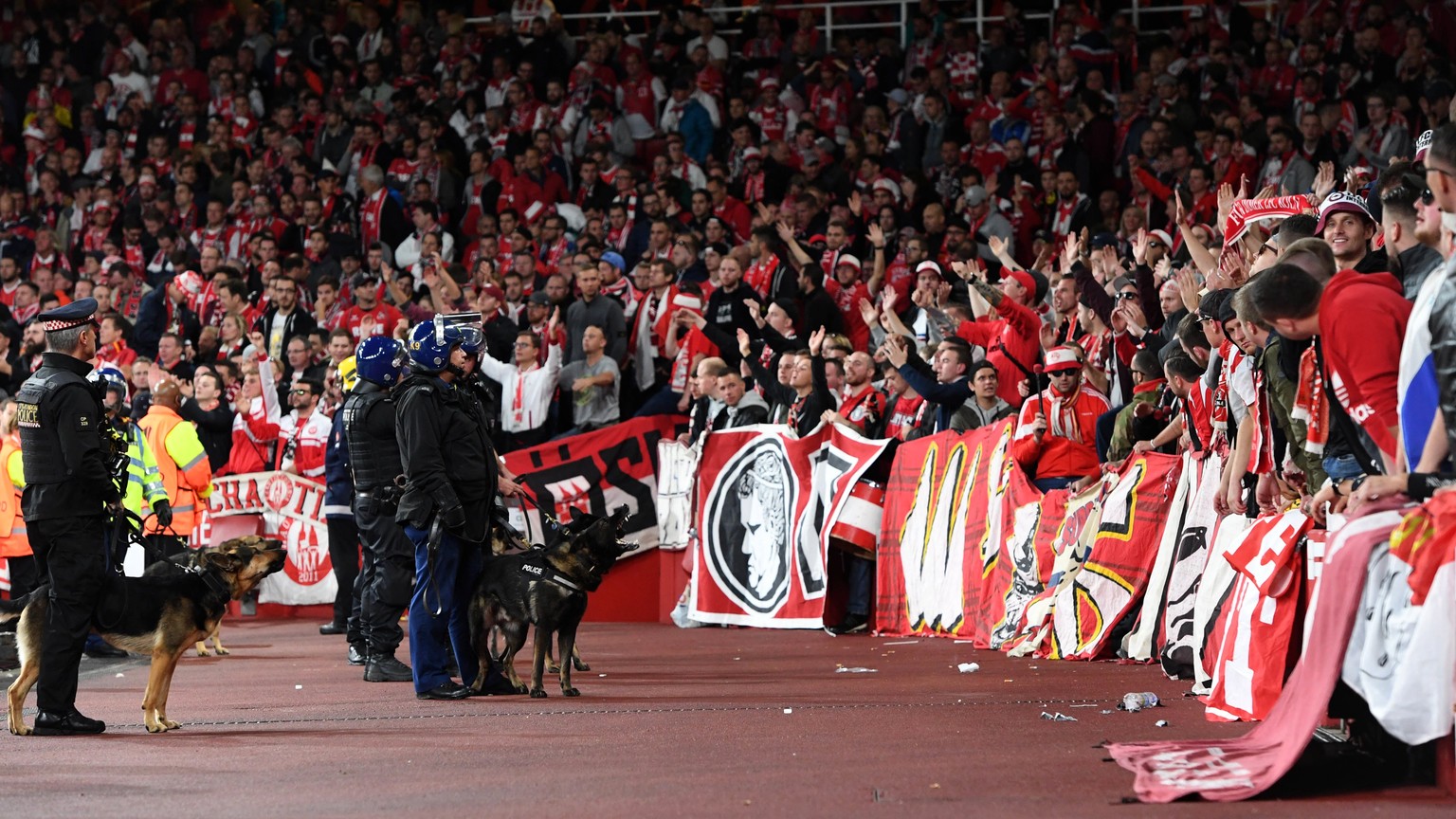 epa06205120 Riot police with dogs patrol in front of Cologne supporters before the delayed UEFA Europa League Group H soccer match between Arsenal FC and FC Cologne at the Emirates Stadium in London,  ...