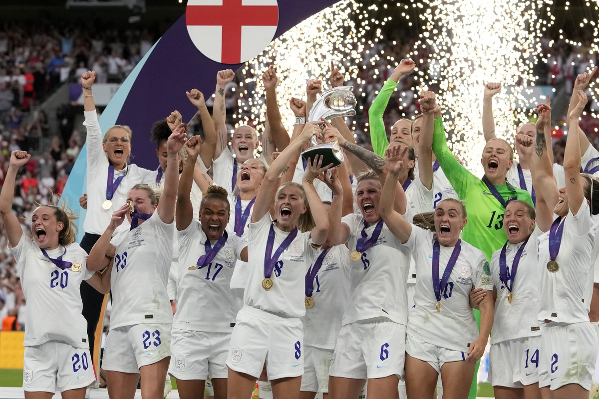 FILE - England's Leah Williamson, center left, and Millie Bright lift the trophy after winning the Women's Euro 2022 final soccer match between England and Germany at Wembley stadium in Lond ...