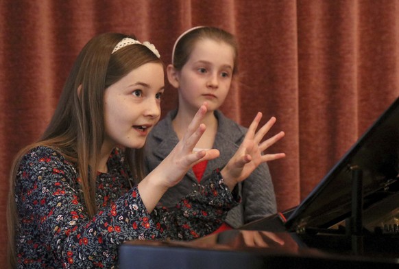 In this Nov. 17, 2016 picture Alma Deutscher and her sister Helen Deutscher, from left, play piano during a rehearsal in Vienna, Austria. Alma Deutscher is a composer, virtuoso pianist and concert vio ...