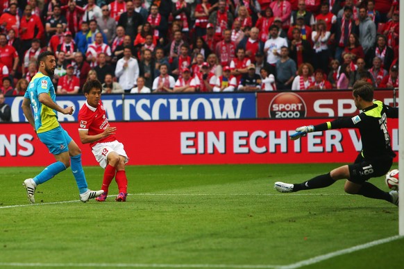 MAINZ, GERMANY - MAY 16: Ja-Cheol Koo of Mainz scores his team's first goal against goalkeeper Thomas Kessler and Dominic Maroh of Koeln during the Bundesliga match between 1. FSV Mainz 05 and 1. FC Koeln at Coface Arena on May 16, 2015 in Mainz, Germany.  (Photo by Alex Grimm/Bongarts/Getty Images)