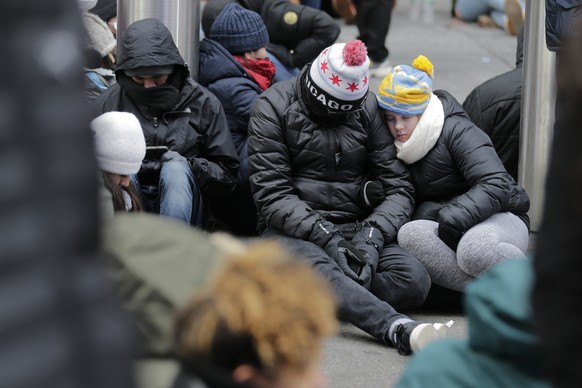 People rest on the ground as they wait for midnight in Times Square in New York on New Year&#039;s Eve, Tuesday, Dec. 31, 2019. Revelers around the globe are bidding farewell to a decade that will be  ...