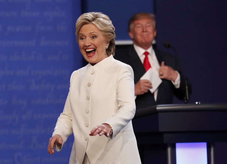 Democratic U.S. presidential nominee Hillary Clinton reacts near Republican U.S. presidential nominee Donald Trump after their third and final 2016 presidential campaign debate at UNLV in Las Vegas, N ...