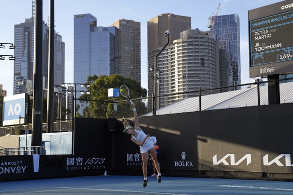 Jil Teichmann of Switzerland serves to Petra Martic of Croatia during their first round match at the Australian Open tennis championships in Melbourne, Australia, Monday, Jan. 17, 2022. (AP Photo/Simo ...