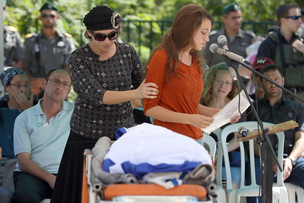 Gilads Schwester Shirel spricht an einer Trauerfeier in Talmon, bevor der Leichnam ihres Bruders nach Modi'in gebracht wird. Ihr Vater Ofir sitzt im Hintergrund (l.), während ihre Mutter Bat-Galim sie ...