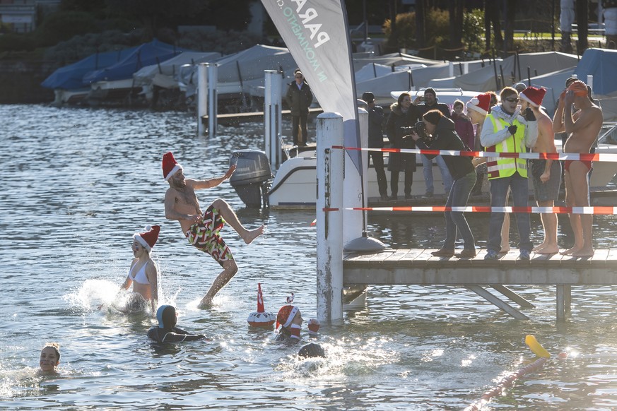 epa08090643 Participants of the annual winter swimming in Paradiso jump into the Lake Lugano on St Stephen&#039;s Day, in Paradiso, Switzerland, 26 December 2019. Around 80 swimmers participated in th ...