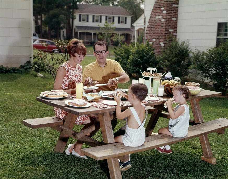 1960s FAMILY OF FOUR AT BACKYARD PICNIC TABLE (Photo by H. Armstrong Roberts/ClassicStock/Getty Images)