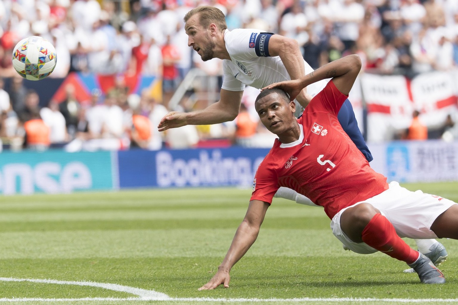 England&#039;s forward Harry Kane, behind, fights for the ball with Switzerland&#039;s defender Manuel Akanji, in red, during the UEFA Nations League third place soccer match between Switzerland and E ...