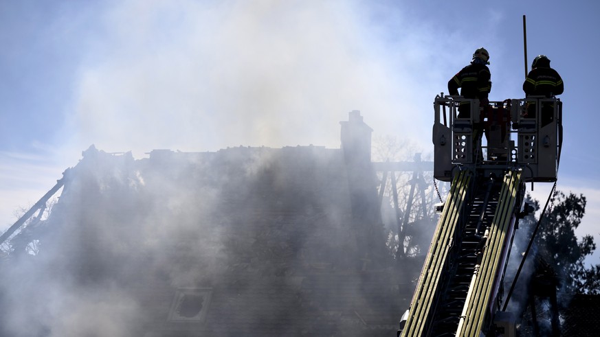 epa10511296 Firefighters on a ladder approach a villa as smoke escapes after a fire, in Yverdon-les-Bains, Switzerland, 09 March 2023. According to the Vaudois police, several bodies were found in a v ...